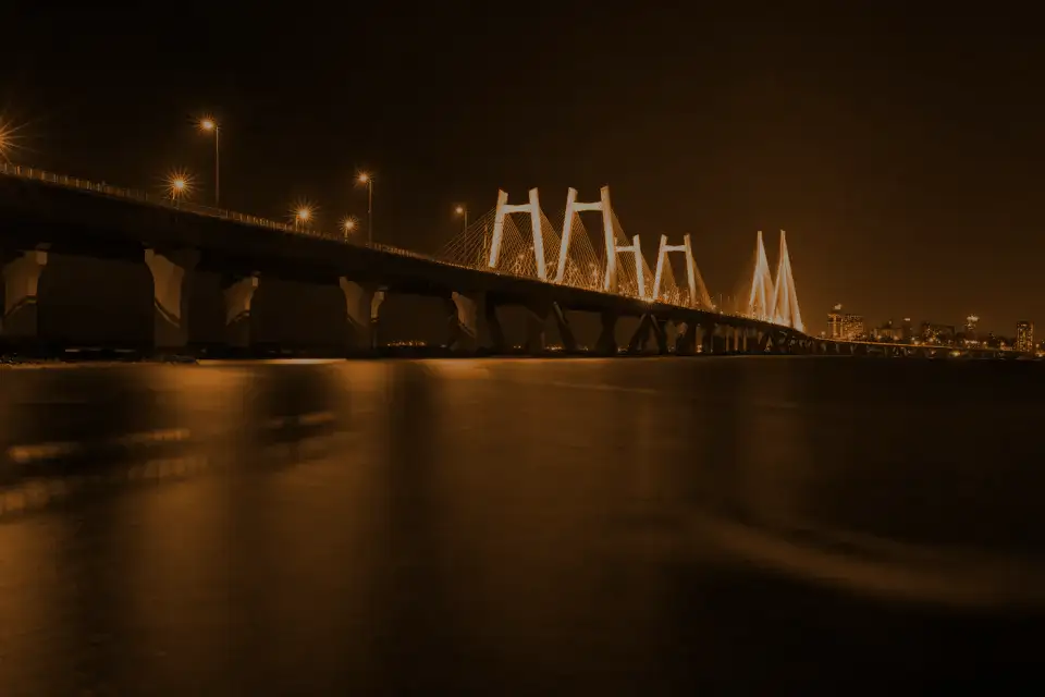 A cable-stayed sea bridge lit up over black water