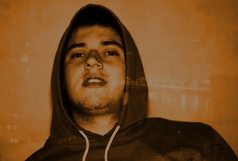 A young man with his hood up, close to the lens